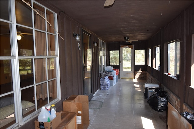 unfurnished sunroom featuring wood ceiling and a ceiling fan