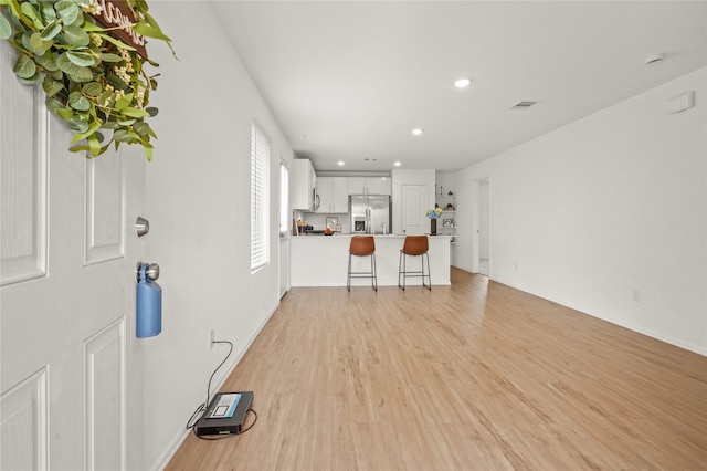 unfurnished living room with light wood-style flooring, visible vents, and recessed lighting