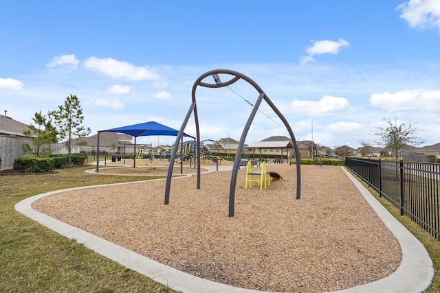 community play area featuring a yard and fence