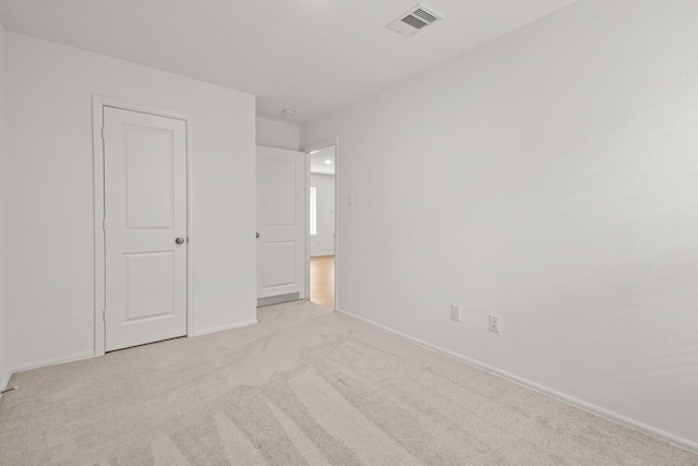 unfurnished bedroom with light carpet, visible vents, and baseboards