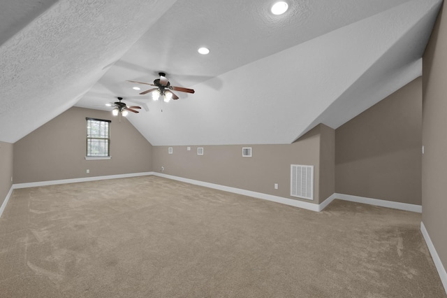 bonus room with baseboards, visible vents, lofted ceiling, a textured ceiling, and carpet floors