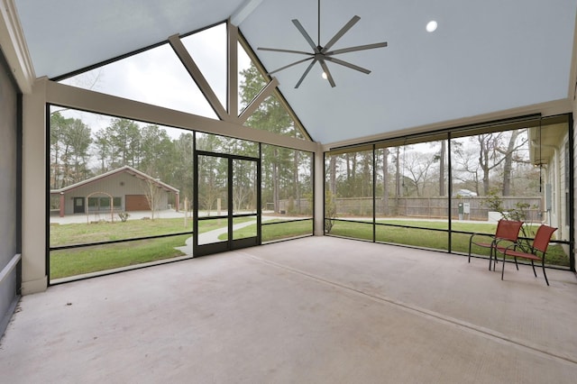 unfurnished sunroom featuring a ceiling fan and vaulted ceiling