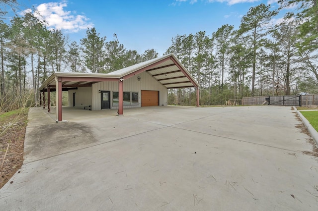 view of side of property with a garage, an outbuilding, fence, and board and batten siding