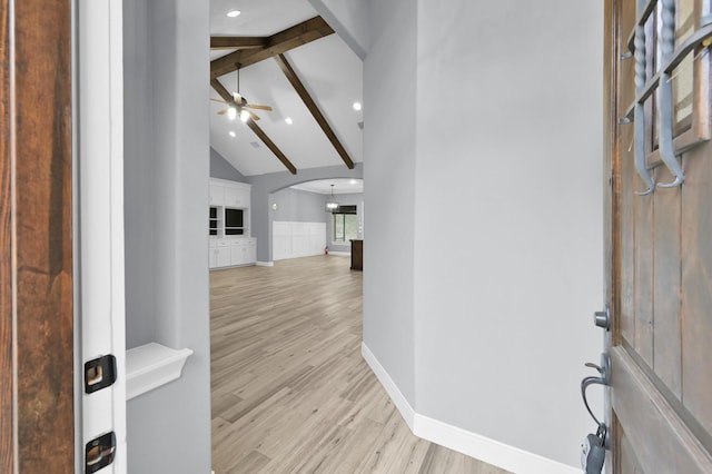 entryway with arched walkways, a ceiling fan, baseboards, light wood-style floors, and beam ceiling