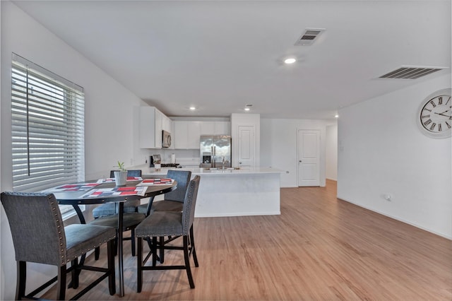 dining room featuring light wood finished floors, visible vents, and recessed lighting