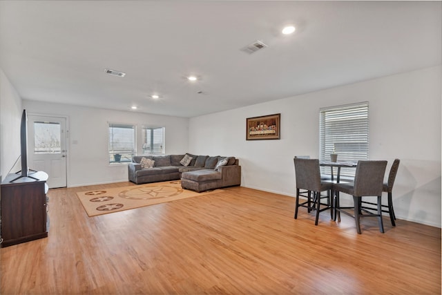 living room featuring baseboards, wood finished floors, visible vents, and recessed lighting