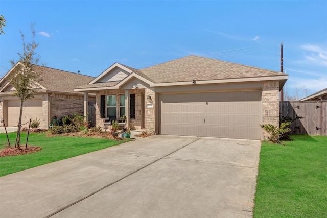 ranch-style home featuring concrete driveway, roof with shingles, an attached garage, a front yard, and brick siding