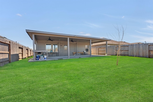 rear view of property with ceiling fan, a yard, a patio area, and a fenced backyard