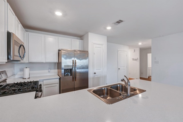 kitchen featuring visible vents, white cabinets, appliances with stainless steel finishes, light countertops, and a sink