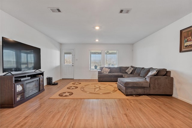 living room with light wood-type flooring, baseboards, visible vents, and recessed lighting