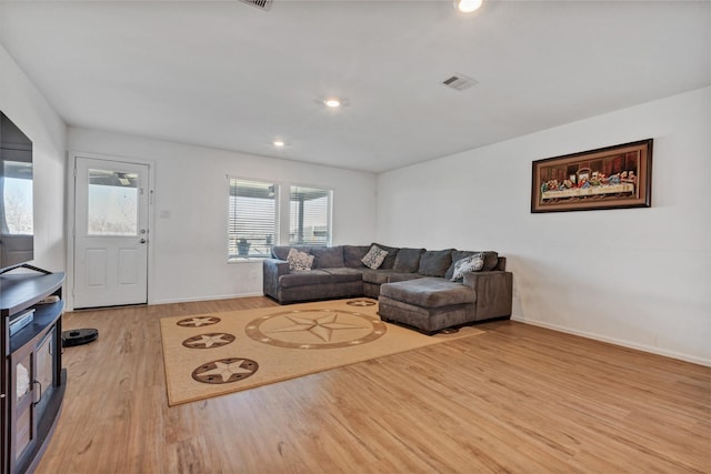 living area with light wood-type flooring, visible vents, baseboards, and recessed lighting