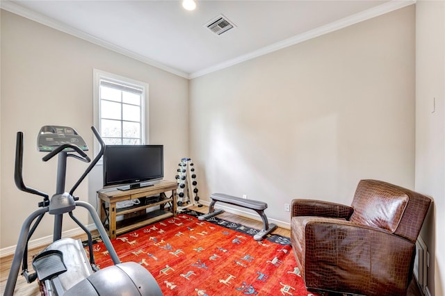 sitting room with ornamental molding, wood finished floors, visible vents, and baseboards