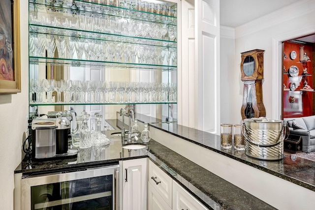 bar featuring ornamental molding, wet bar, beverage cooler, and a sink