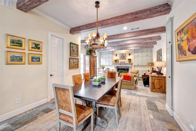 dining room featuring stone tile flooring, visible vents, a fireplace, and baseboards