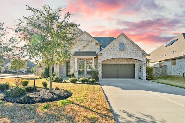 view of front facade featuring a garage, brick siding, concrete driveway, a yard, and stone siding