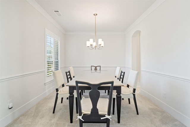 dining area with ornamental molding, arched walkways, light carpet, and visible vents