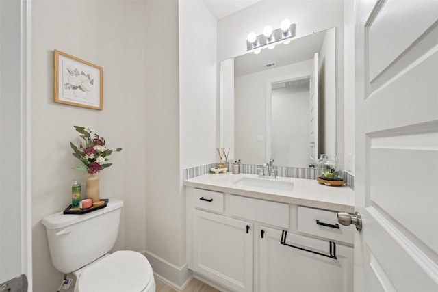 bathroom with visible vents, vanity, and toilet