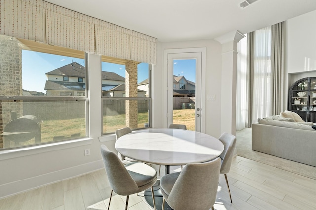 dining space with wood finished floors, a wealth of natural light, and baseboards