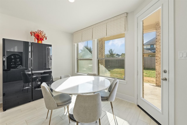 dining area with light wood-style flooring and baseboards