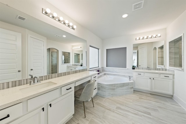 full bathroom featuring a stall shower, visible vents, a sink, and a bath