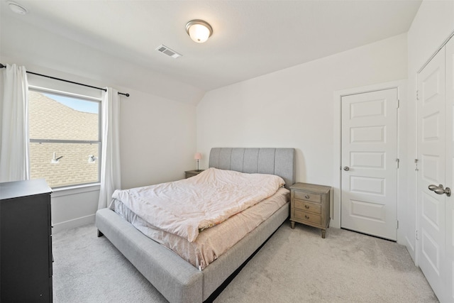 bedroom with light colored carpet, visible vents, vaulted ceiling, and baseboards