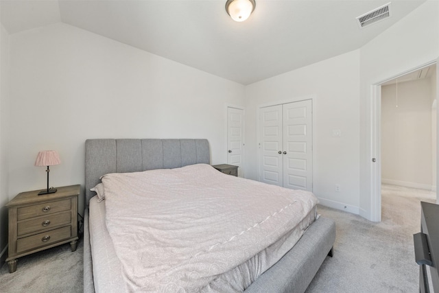 bedroom with a closet, light colored carpet, visible vents, attic access, and baseboards