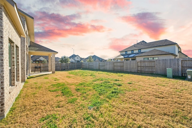 yard at dusk featuring a patio area and a fenced backyard