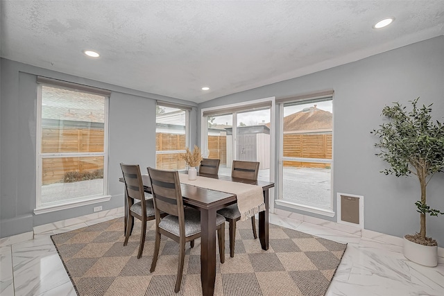 dining area with a textured ceiling, marble finish floor, and recessed lighting