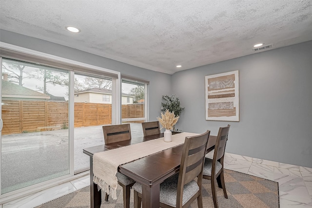 dining room featuring recessed lighting, marble finish floor, visible vents, and a textured ceiling