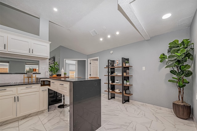 kitchen featuring dark countertops, marble finish floor, wine cooler, and vaulted ceiling