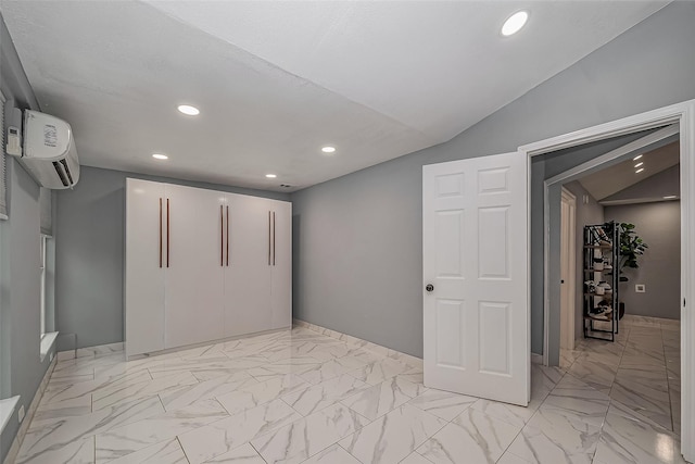 basement featuring marble finish floor, an AC wall unit, and recessed lighting