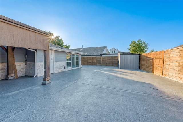 view of patio / terrace featuring a fenced backyard, an outdoor structure, and a storage unit