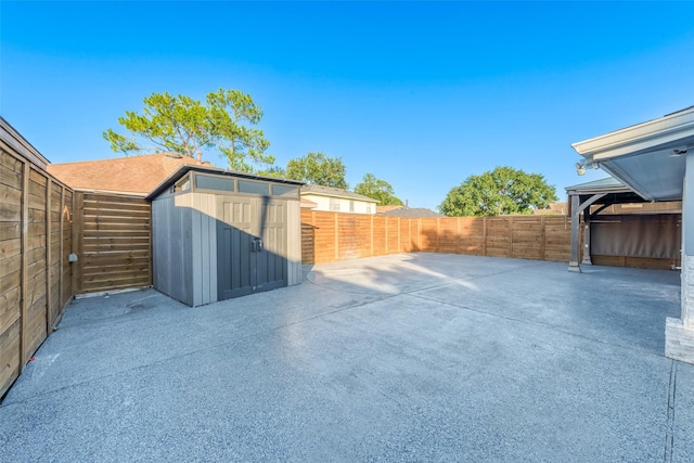 view of patio with an outbuilding, a shed, and a fenced backyard