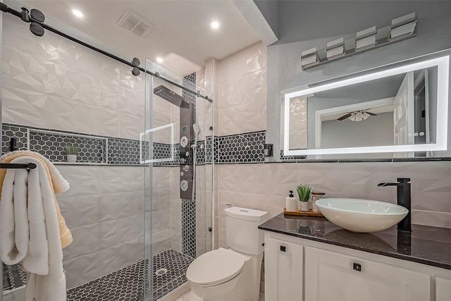 full bathroom featuring tile walls, visible vents, backsplash, toilet, and a stall shower