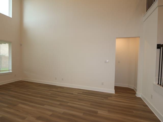 21706 Persian Lake Dr, Cypress, TX 77433 - unfurnished room with a towering ceiling and dark wood-style flooring