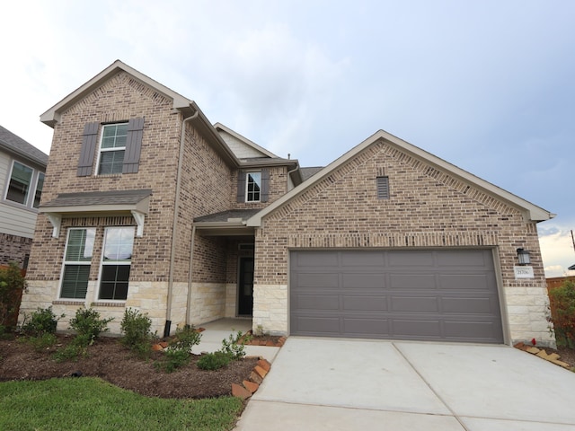 21706 Persian Lake Dr, Cypress, TX 77433 - view of front facade with driveway, brick siding, an attached garage, and stone siding