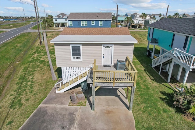 view of front of property featuring stairs, a front lawn, cooling unit, and a wooden deck