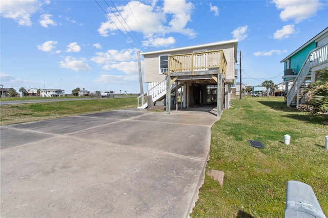 view of front of home with a carport, driveway, stairway, and a front lawn