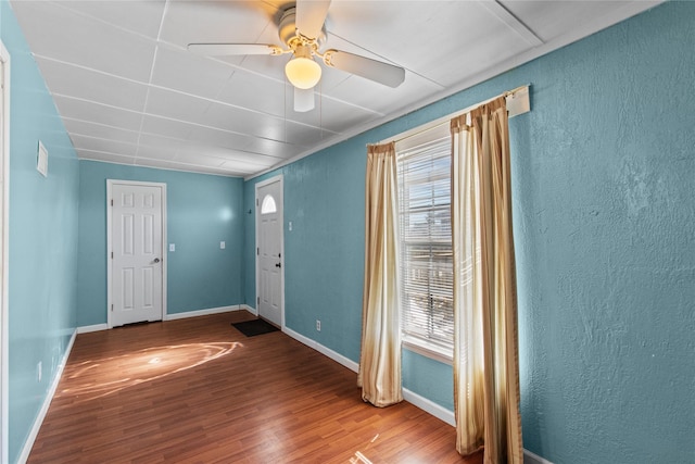 entryway featuring ceiling fan, baseboards, and wood finished floors