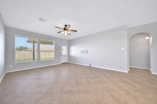 21722 Sierra Long Dr, Richmond, TX 77407 - empty room featuring arched walkways, ceiling fan, light tile patterned floors, visible vents, and baseboards