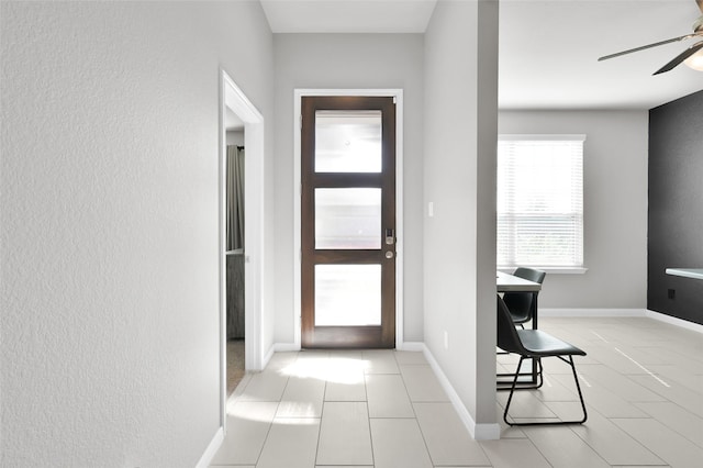 entrance foyer featuring a ceiling fan and baseboards