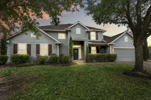 traditional-style house featuring a front lawn, a garage, and driveway