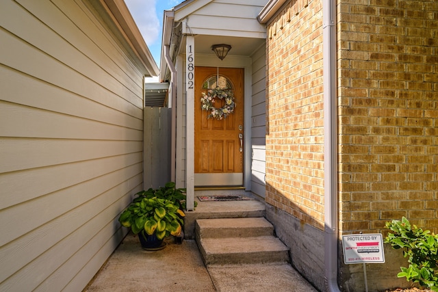 entrance to property featuring brick siding