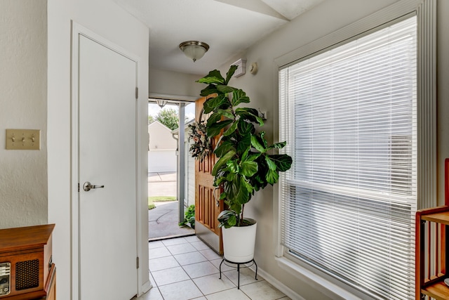 doorway to outside with light tile patterned floors