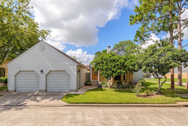 view of front of property with an attached garage, a front lawn, and concrete driveway