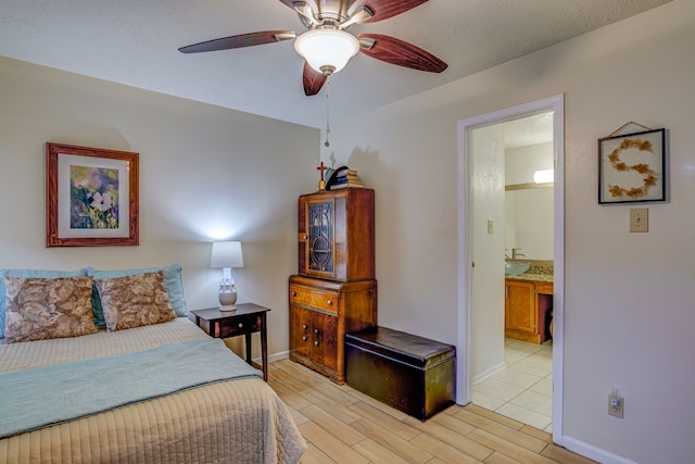 bedroom featuring light wood-style floors, ceiling fan, baseboards, and connected bathroom