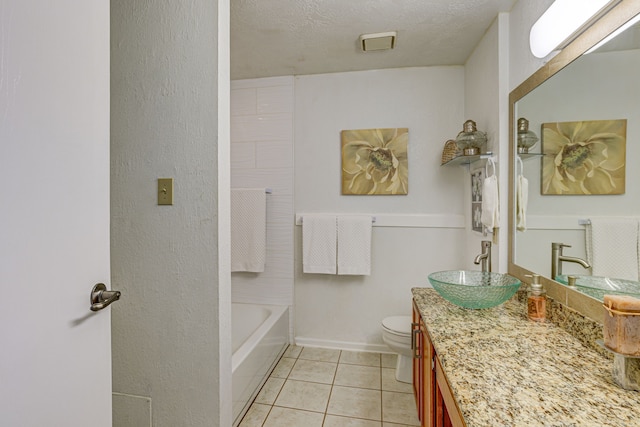 full bathroom with baseboards, toilet, tile patterned floors, a textured ceiling, and vanity