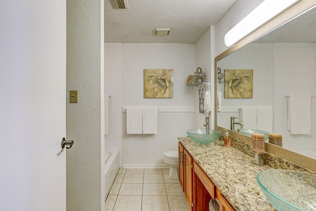 bathroom featuring toilet, tile patterned flooring, a textured ceiling, and a sink