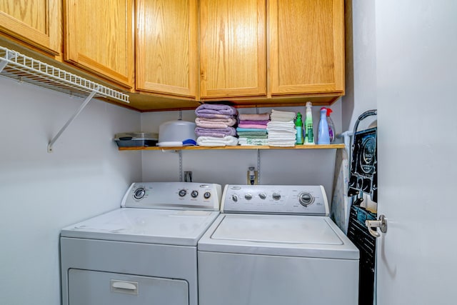 laundry room with washing machine and clothes dryer and cabinet space