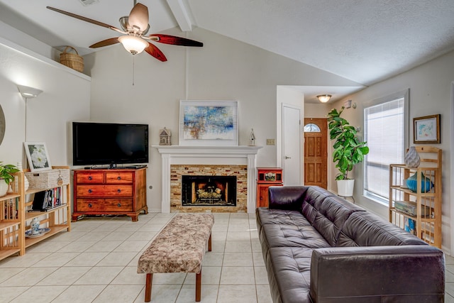 living area featuring light tile patterned flooring, vaulted ceiling with beams, a fireplace, and ceiling fan